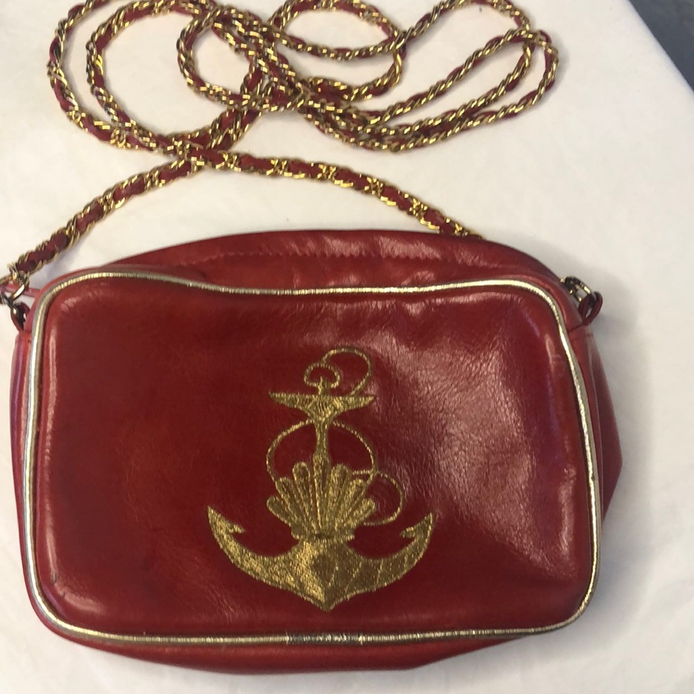 LJ SIMONE red and gold leather crossbody with anchor on front. Trimmed in gold.